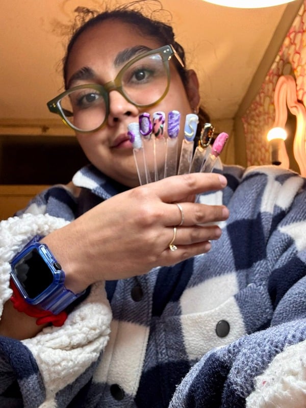 Mary Alarcón mostrando diseños de uñas