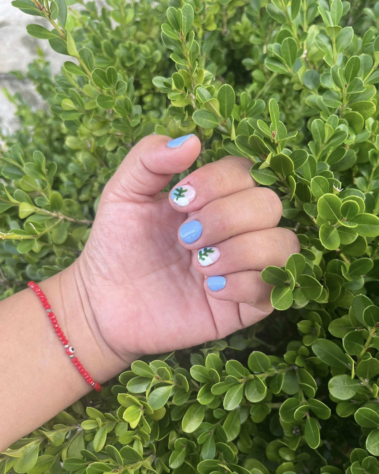 Uñas cortas azul cielo con diseño de margaritas